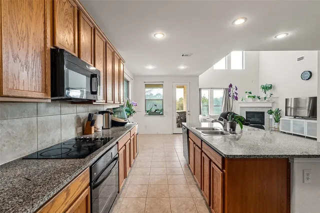 a kitchen with stainless steel appliances granite countertop a refrigerator a stove and a sink