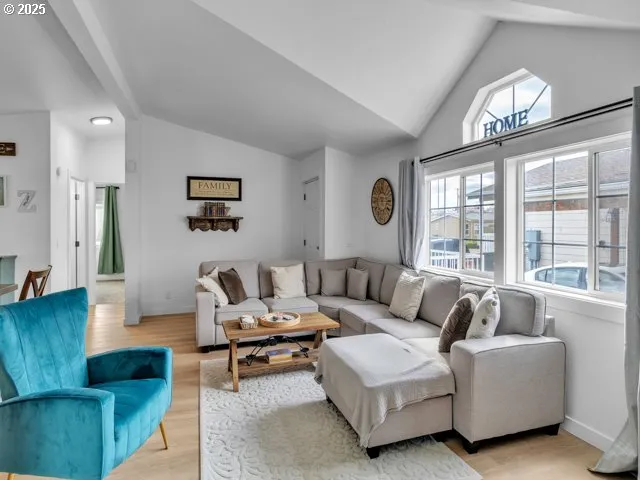 a living room with furniture wooden floor and a large window