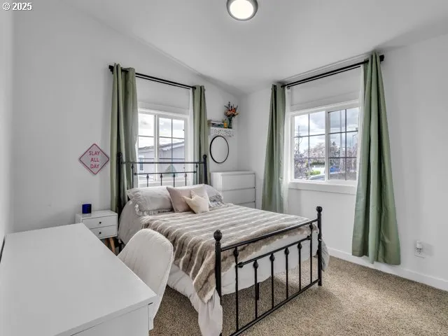 a bedroom with a bed next to a window