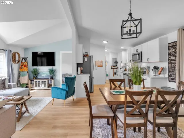 a view of a dining room with furniture a rug and wooden floor