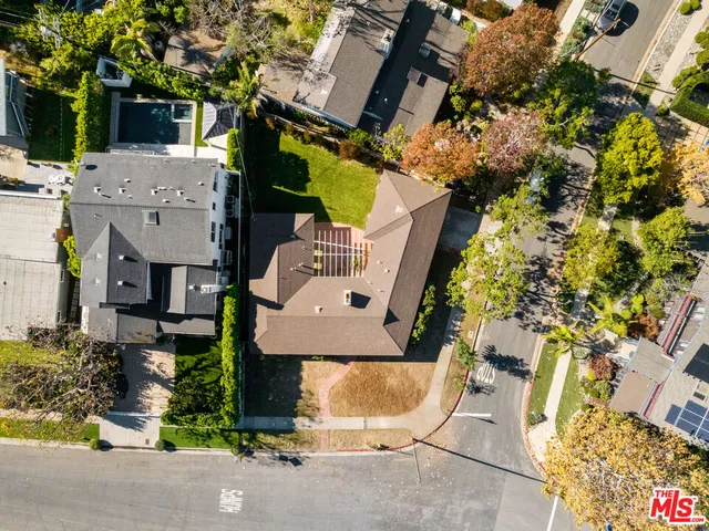 an aerial view of a house with a yard and a large tree