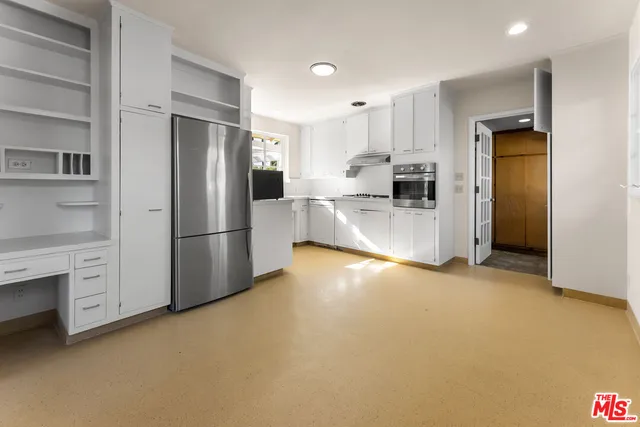 a kitchen with stainless steel appliances a refrigerator and a stove top oven