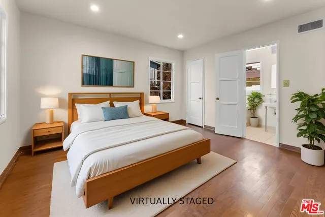 a bedroom with a large bed and a potted plant
