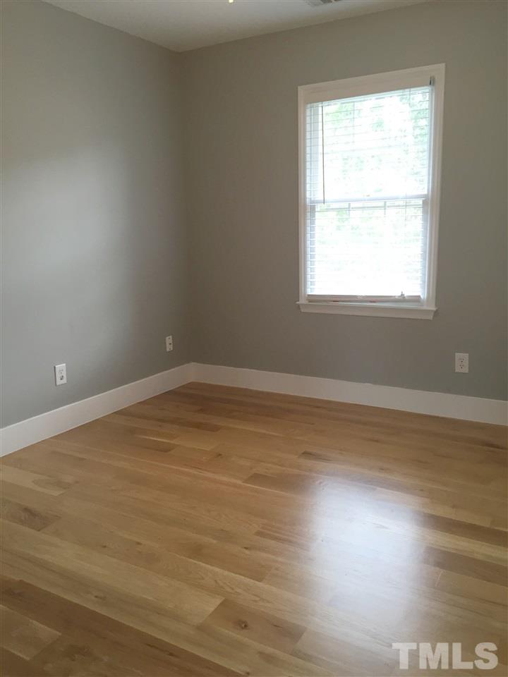 11309 North Radner Way Raleigh, NC 27613 - Photo 12 of 25 an empty room with wooden floor and windows