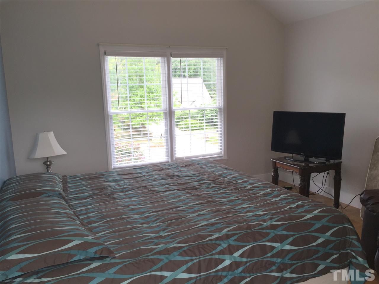 11309 North Radner Way Raleigh, NC 27613 - Photo 17 of 25 a bedroom with a bed and a flat screen tv