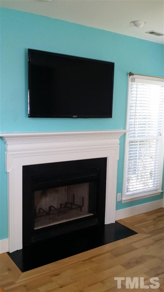 11309 North Radner Way Raleigh, NC 27613 - Photo 8 of 25 a living room with a fireplace and a flat screen tv