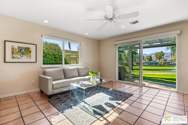 a living room with stainless steel appliances kitchen island granite countertop a refrigerator and a sink