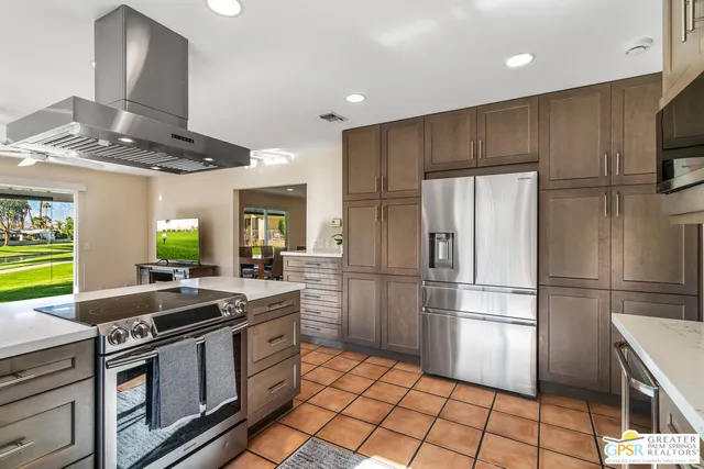 a kitchen with stainless steel appliances granite countertop a stove a refrigerator and a sink