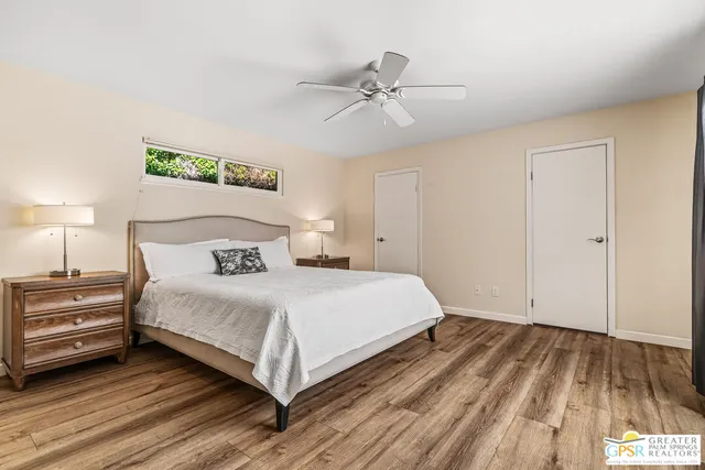 a bathroom with a granite countertop sink a toilet a mirror and a window