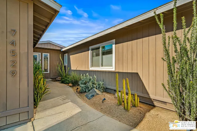 a house with potted plants in front of door
