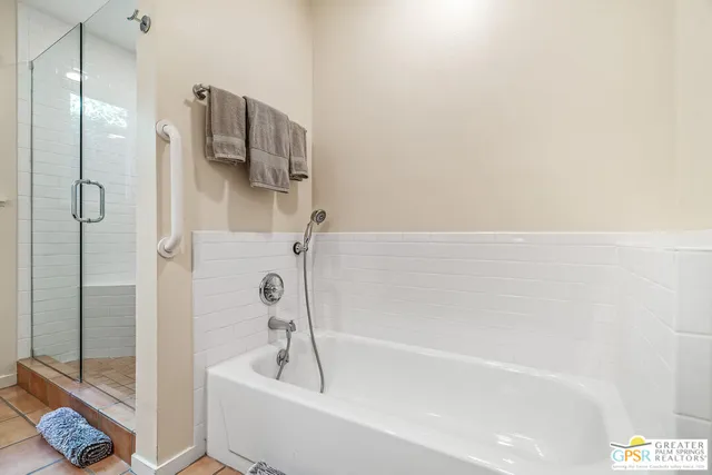 a bedroom with a large bed and a chandelier fan