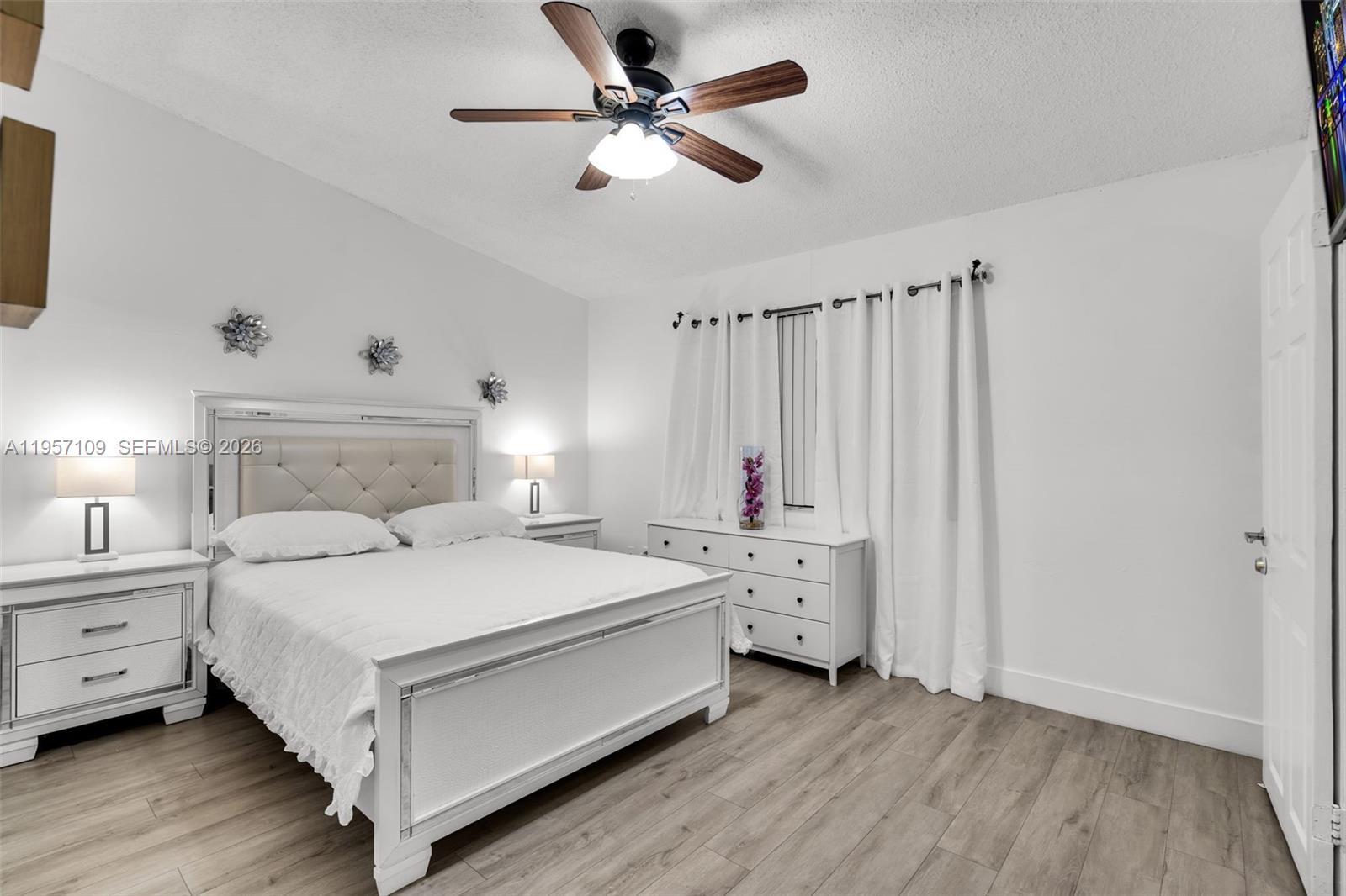 7531 West 29th Way, Unit 7531 Hialeah, FL 33018 - Photo 12 of 30 a bedroom with a bed and a chandelier