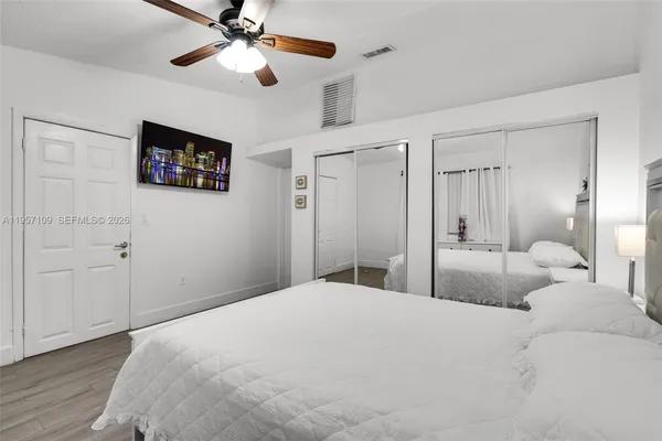 a bedroom with a bed and a ceiling fan