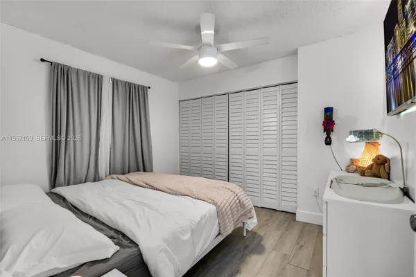 a bedroom with a large bed and a flat tv screen
