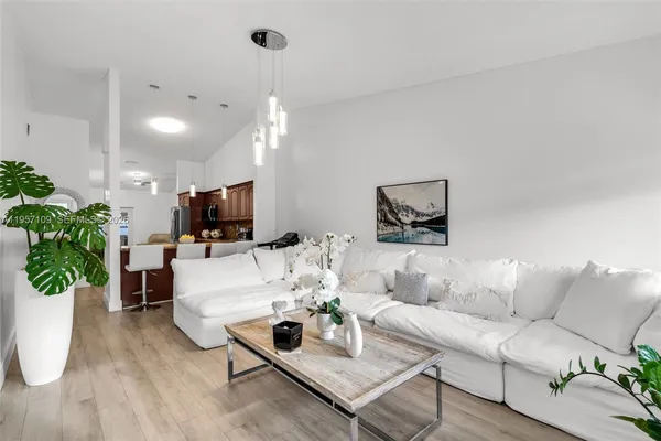 a living room with furniture a potted plant and a flat screen tv