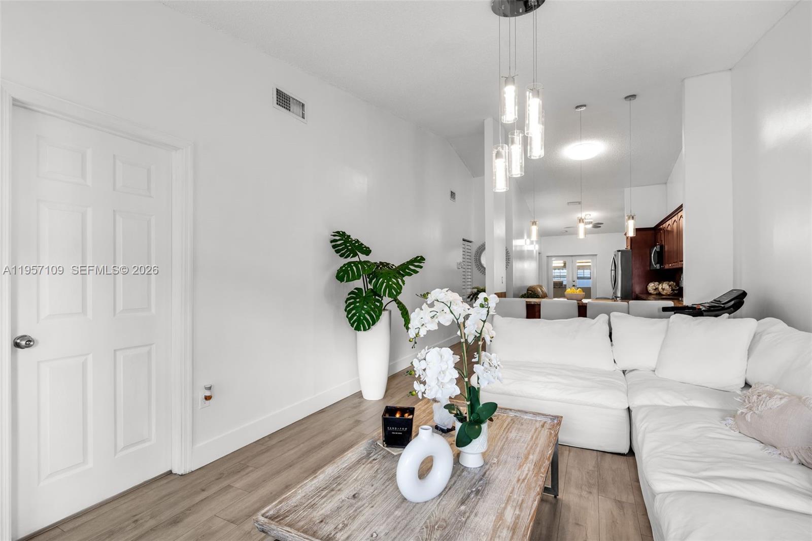 7531 West 29th Way, Unit 7531 Hialeah, FL 33018 - Photo 4 of 30 a living room with furniture and a chandelier