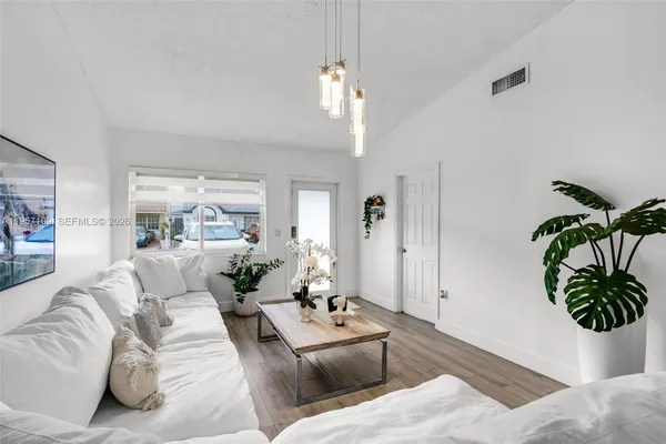 a living room with furniture potted plant and a large mirror