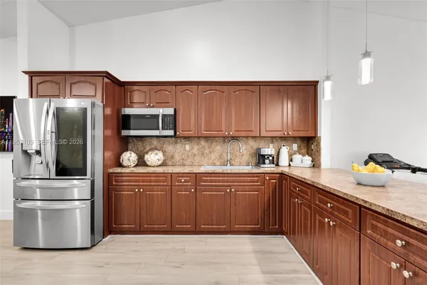 a kitchen with stainless steel appliances granite countertop a refrigerator and a sink