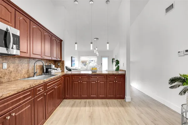 a kitchen with stainless steel appliances granite countertop wooden cabinets a sink and dishwasher