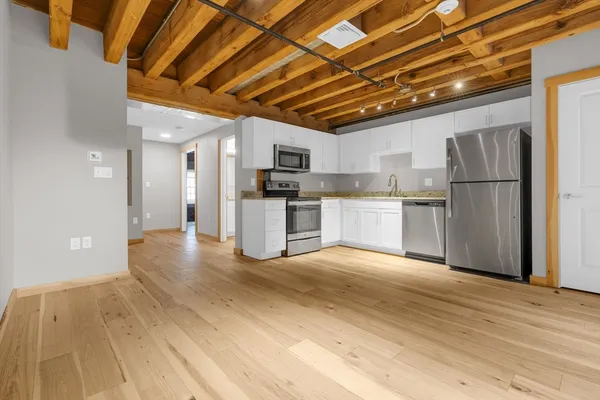 a view of a kitchen with a sink and a refrigerator