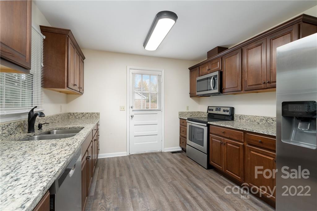 1500 Rama Road Charlotte, NC 28211 - Photo 7 of 25 a kitchen with granite countertop a sink wooden cabinets and stainless steel appliances