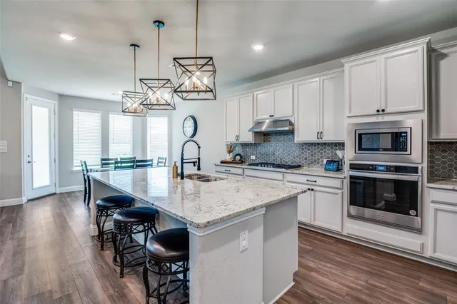 a kitchen with kitchen island a dining table and chairs