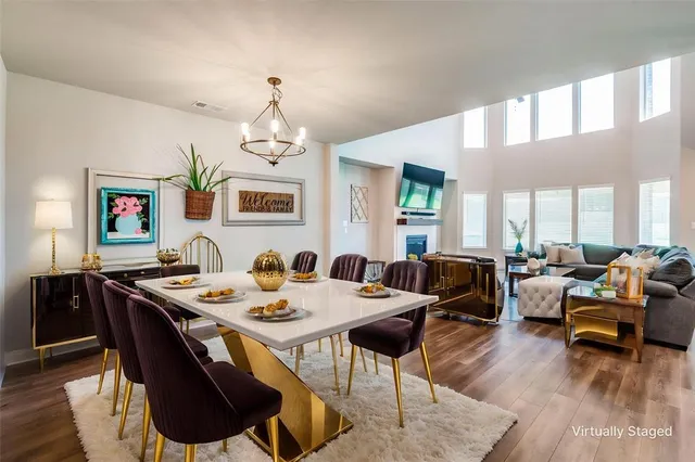 a dining room with wooden floor a chandelier a wooden table and chairs