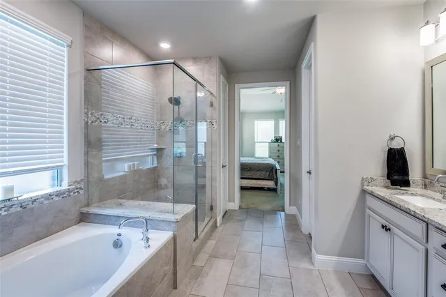 a bathroom with a granite countertop sink a mirror and a bathtub