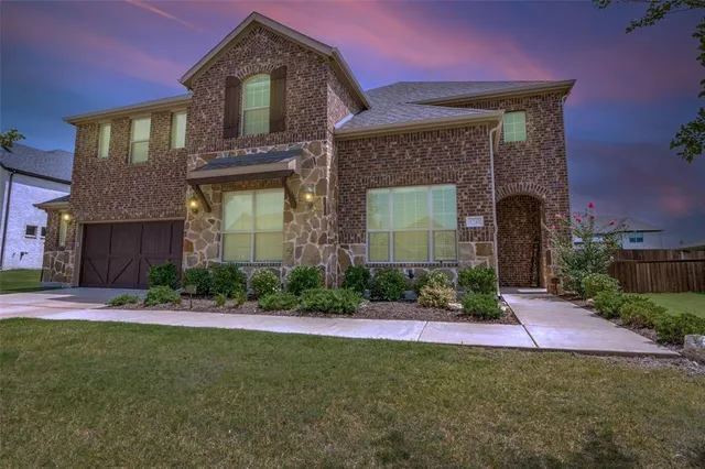 a front view of a house with a garden and plants