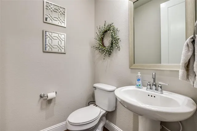 a bathroom with a sink toilet and a mirror