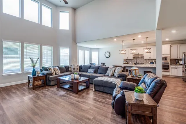 a living room with furniture kitchen view and a large window