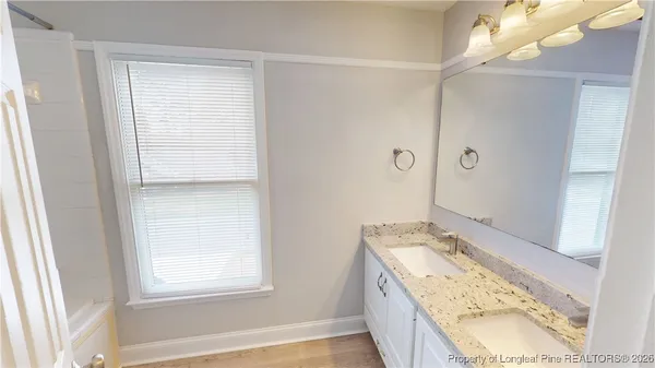 a bathroom with a granite countertop sink a toilet and vanity