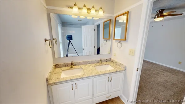 a bathroom with a granite countertop sink and a mirror