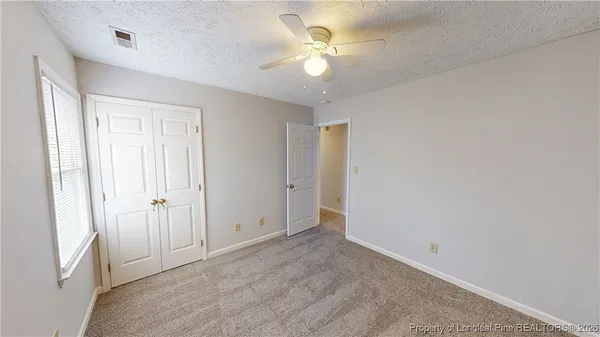 an empty room with a ceiling fan and a window