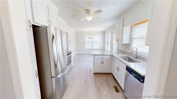 a kitchen with stainless steel appliances a stove a sink and a refrigerator