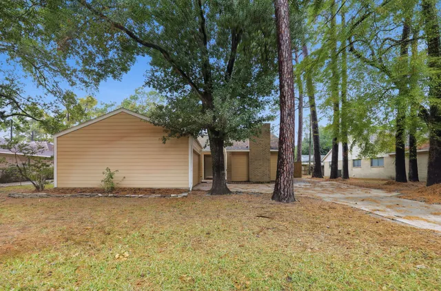 a backyard of a house with large trees and a large tree