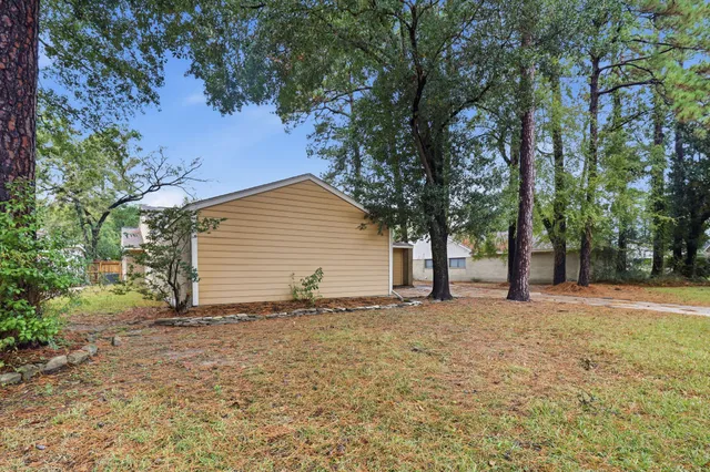 a backyard of a house with large trees and a large tree