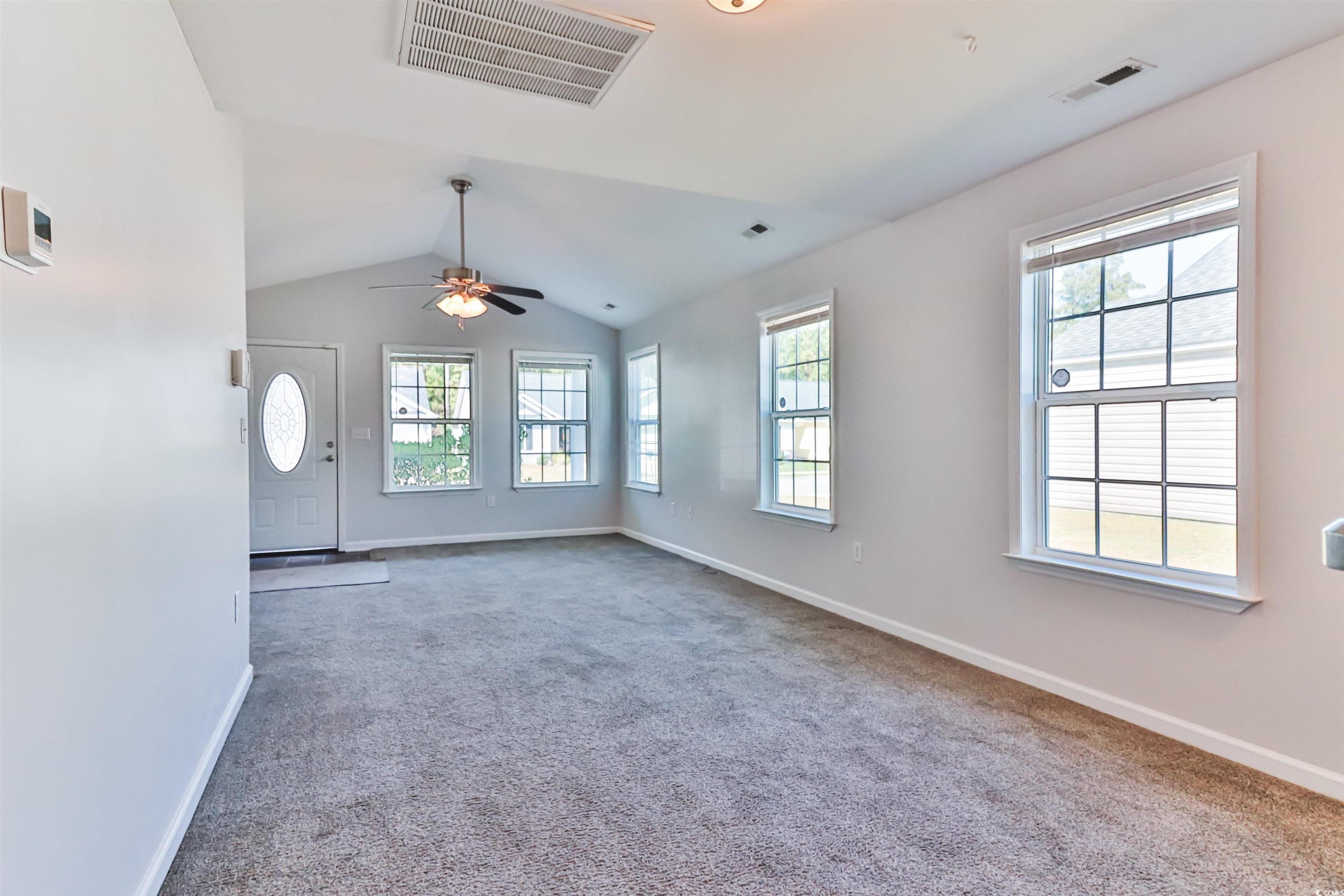 Unfurnished living room with lofted ceiling, carpe