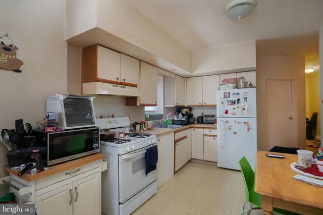 a kitchen with stainless steel appliances a stove a sink cabinets and a refrigerator