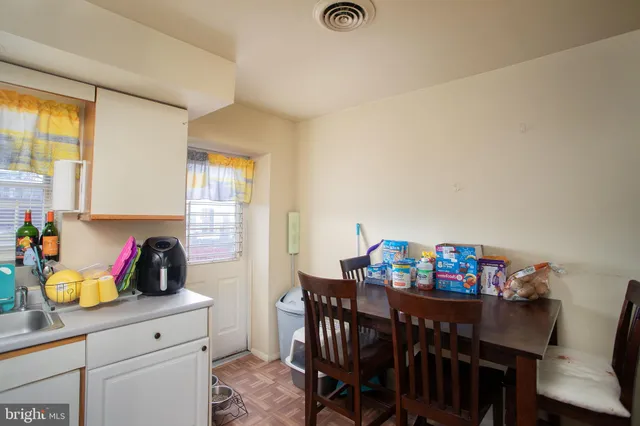 a kitchen with stainless steel appliances a dining table and chairs with wooden floor