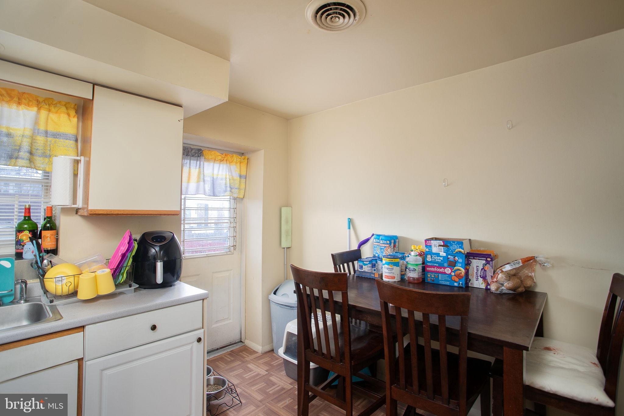 127 Kent Street Trenton, NJ 08611 - Photo 6 of 25 a kitchen with stainless steel appliances a dining table and chairs with wooden floor