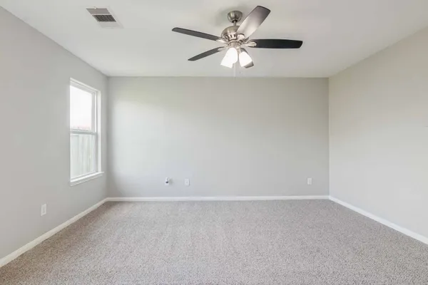 an empty room with a window and a fan