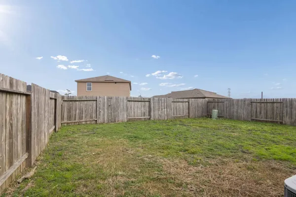 a view of a backyard with wooden fence