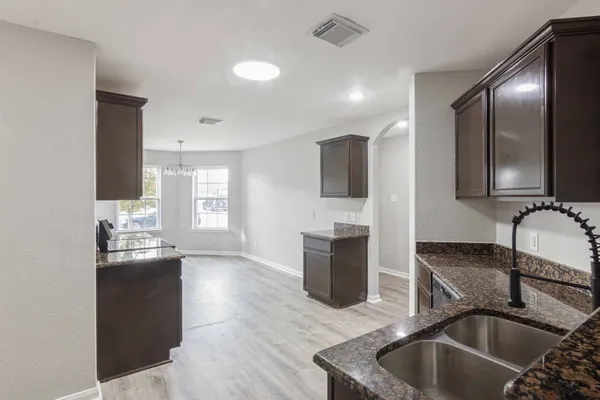 a kitchen with granite countertop a sink and a stove top oven