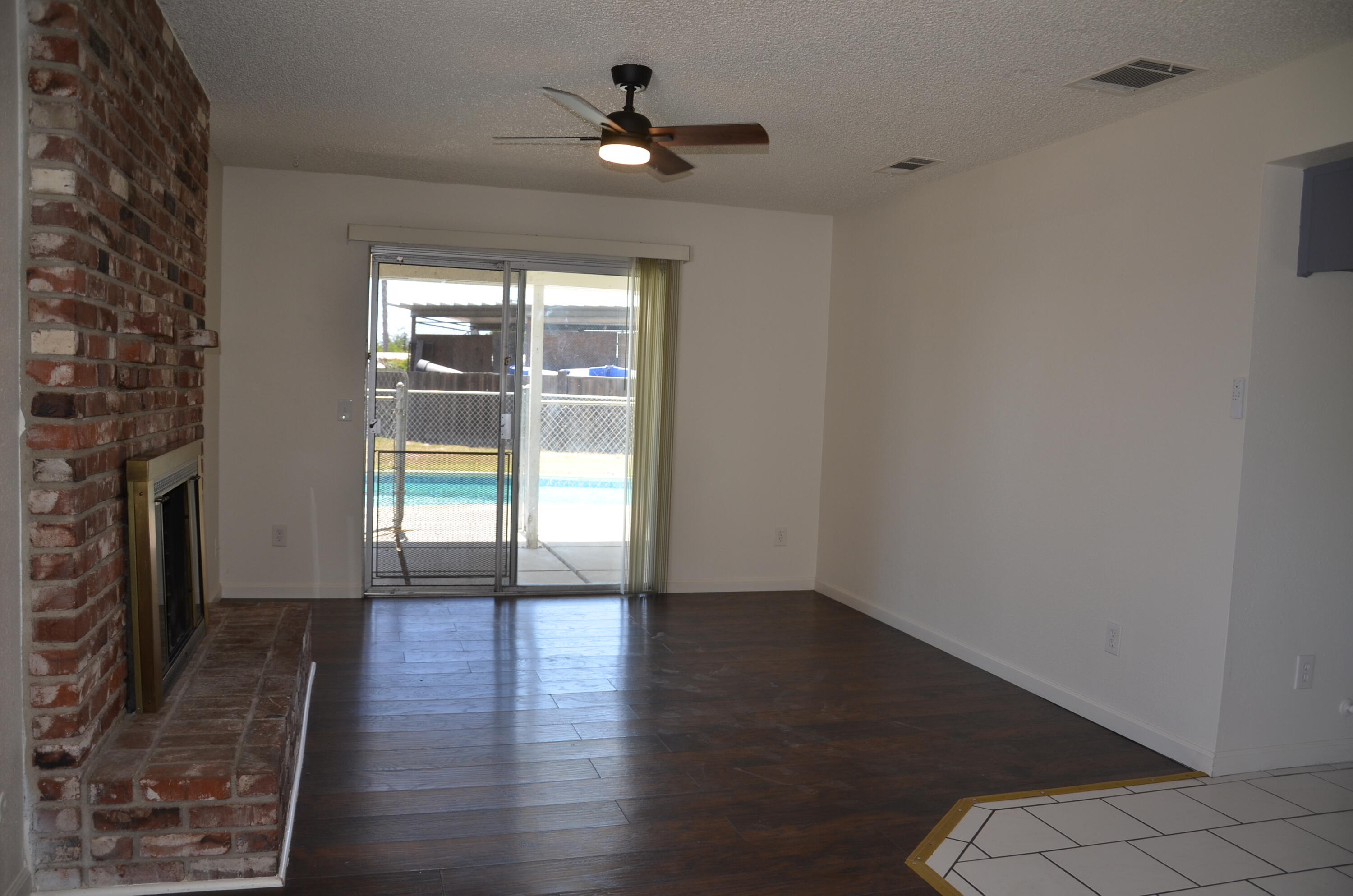 339 West Spring Lane Lemoore, CA 93245 - Photo 4 of 31 wooden floor in an empty room with a window