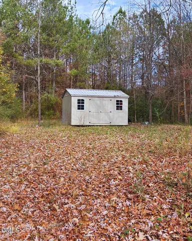 a view of a wooden house with a yard