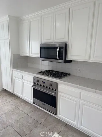 a kitchen with white cabinets and stainless steel appliances