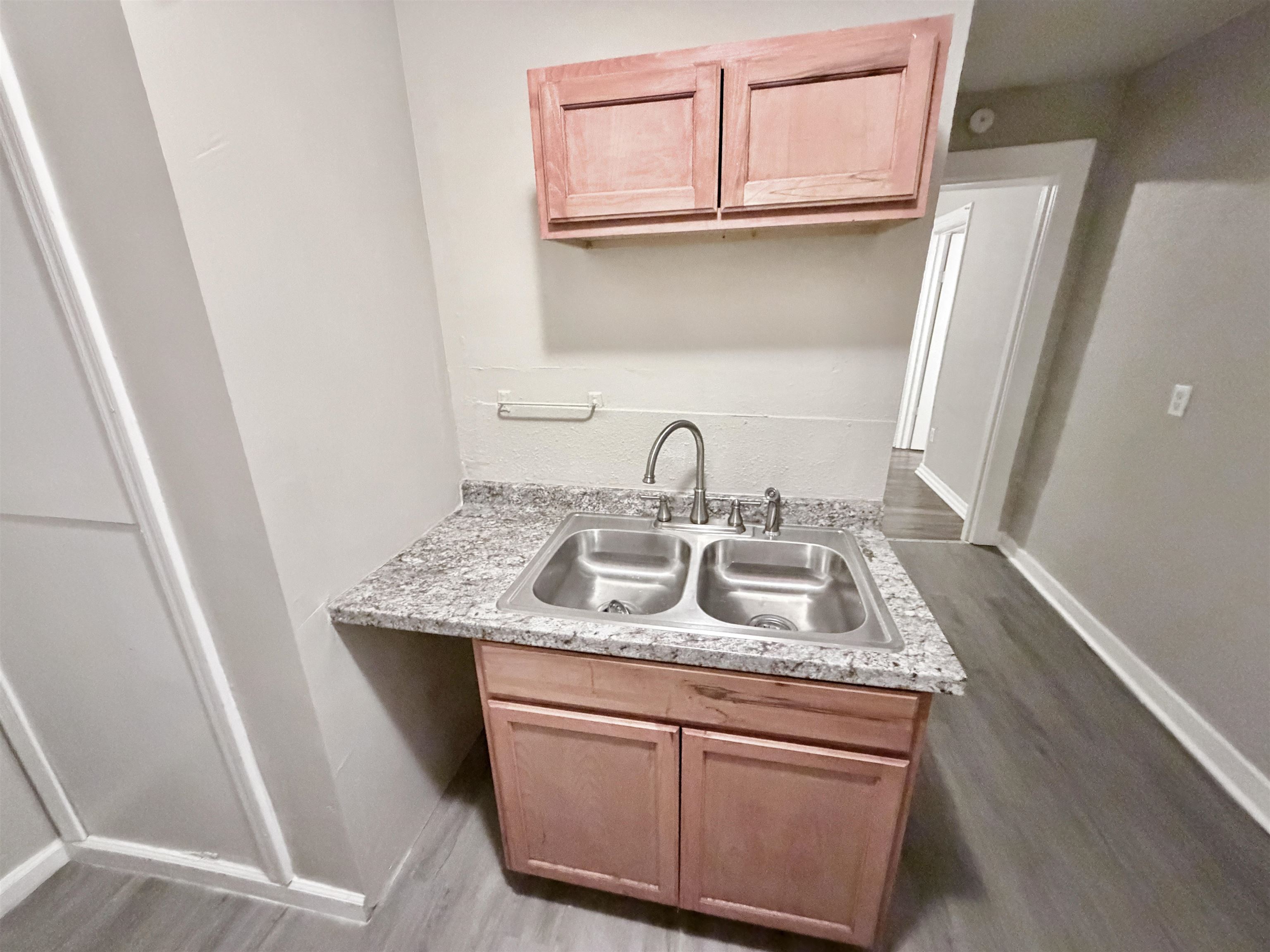 3100 Travis Road Memphis, TN 38109 - Photo 15 of 16 Double basin stainless steel sink with a high-arc faucet, set within a granite-finish countertop