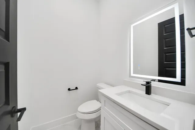 a bathroom with a sink a toilet and a mirror
