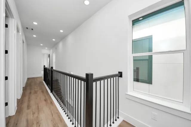 a view of a hallway with wooden floor and entryway